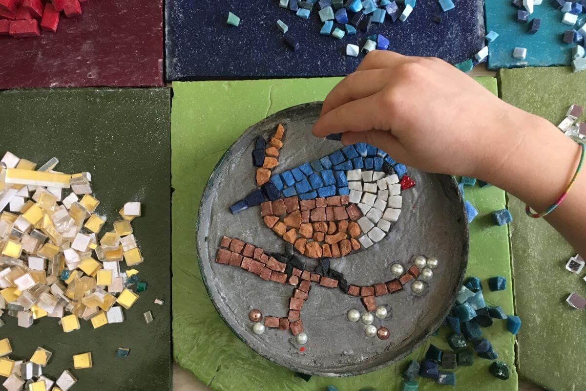 Mano di un bambino che compone un mosaico.