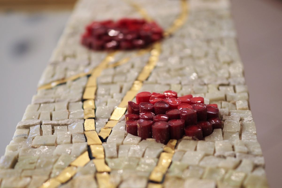 Dettaglio di un opera di Barbara Liverani con due fiori rossi a mosaico.
