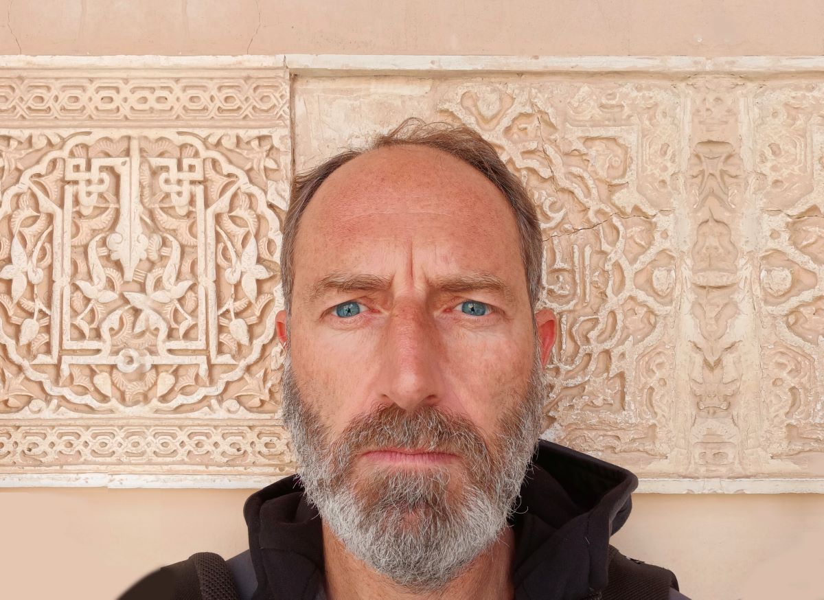 Foto visito del DJ davanti a una parete con decorazioni arabeggianti.