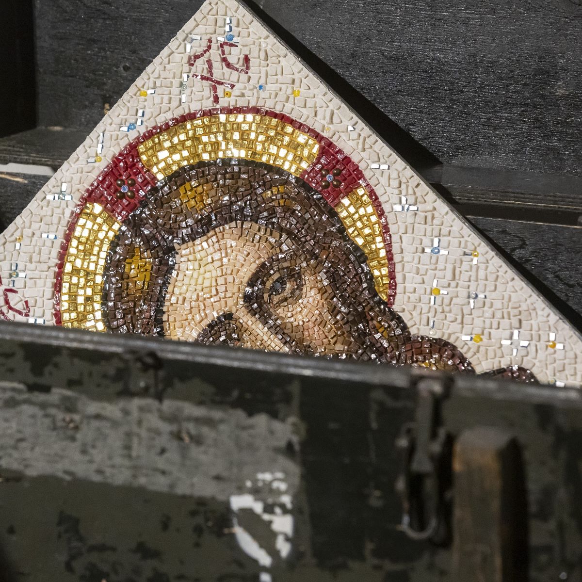 Dettaglio di un mosaico con il volto di cristo che esce da un baule.