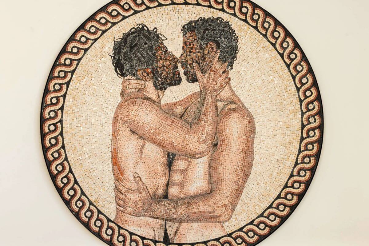 Foto di un mosaico rotondo in cui di ragazzi con il volto pixelati si stanno baciando.