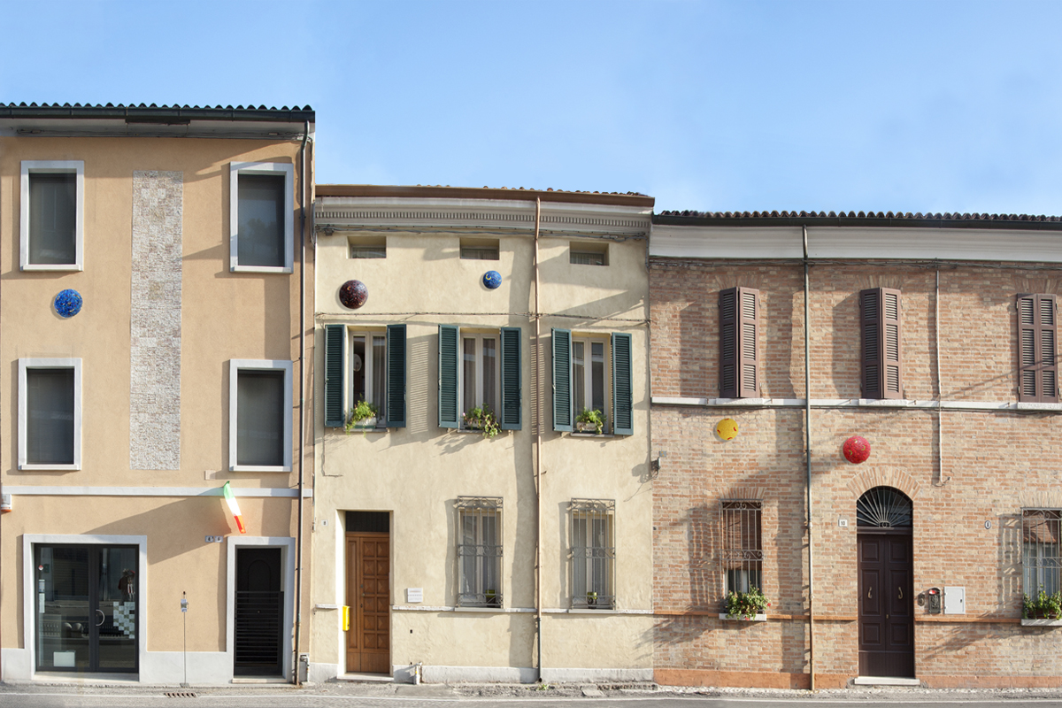Foto delle abitazioni con sulla facciata delle sfere di mosaico.