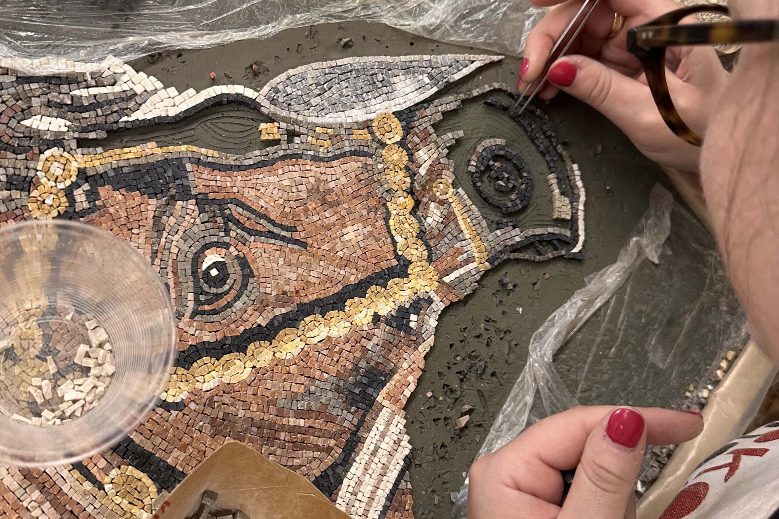Foro di una mosaicista che sta realizzando una testa di cavallo a mosaico.
