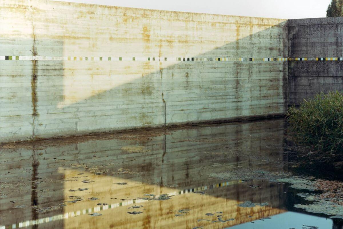 Foto di una porzione di muro della Tomba Brion, lungo il quale corre una fascia di mosaico in tessere d'oro.