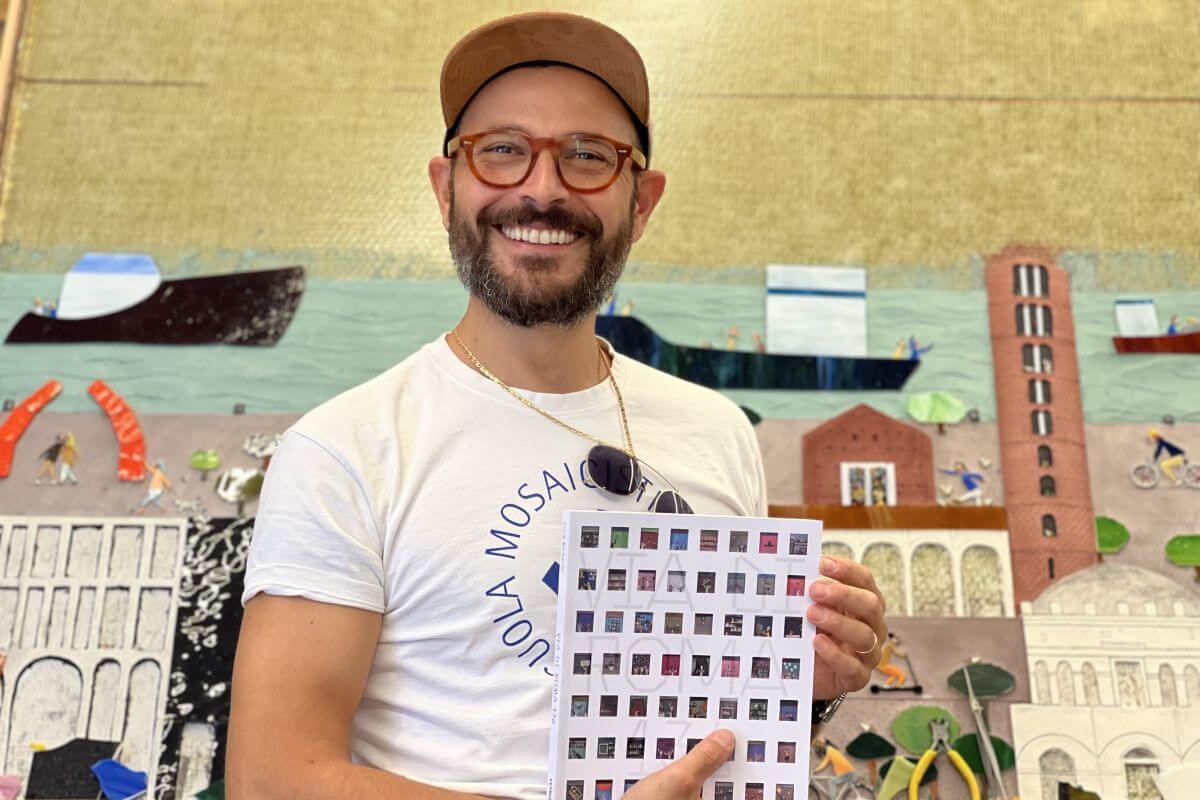Foto di Luca Barberini con in mano il catalogo
