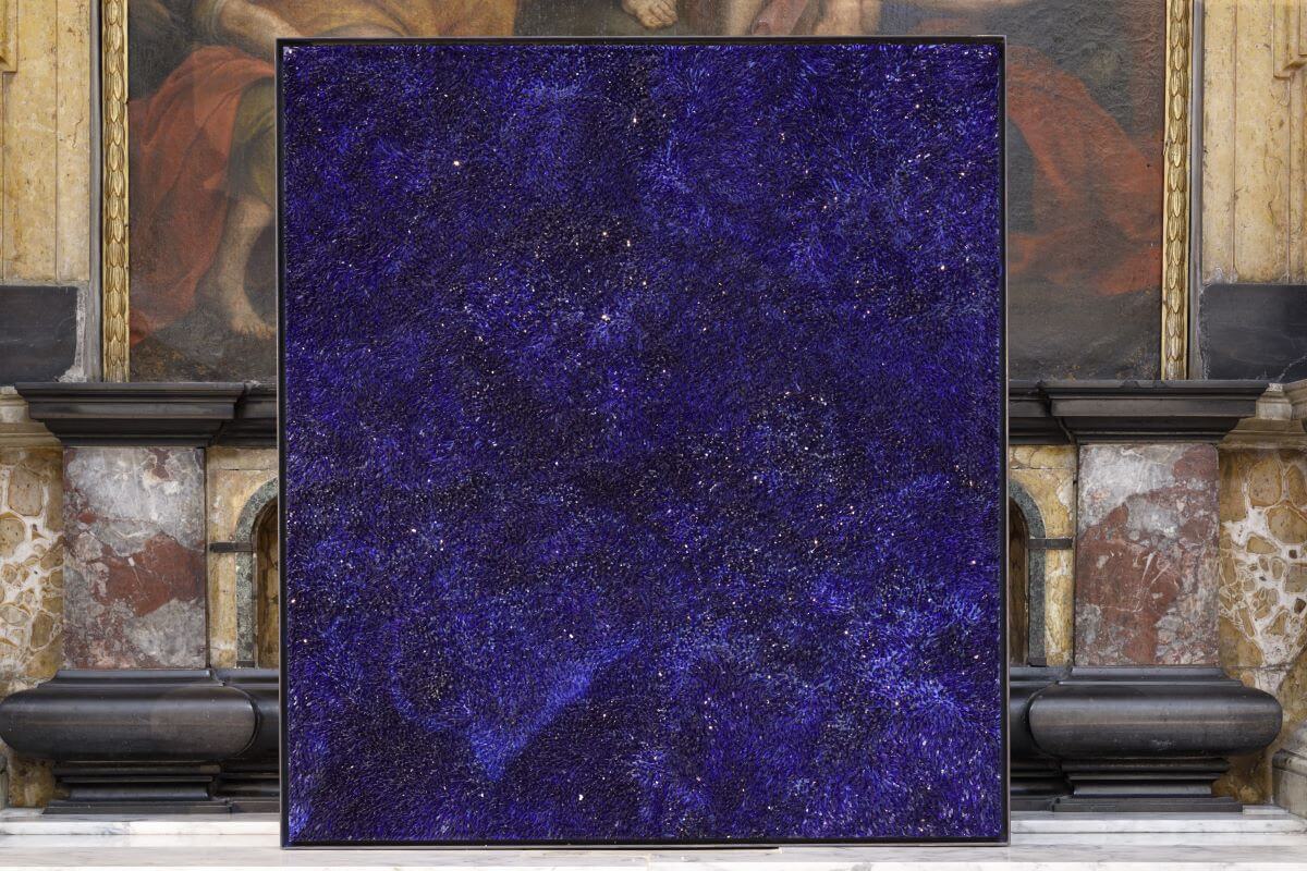 Foto di un'opera quadrata in mosaico blu davanti all'altare di una chiesa.