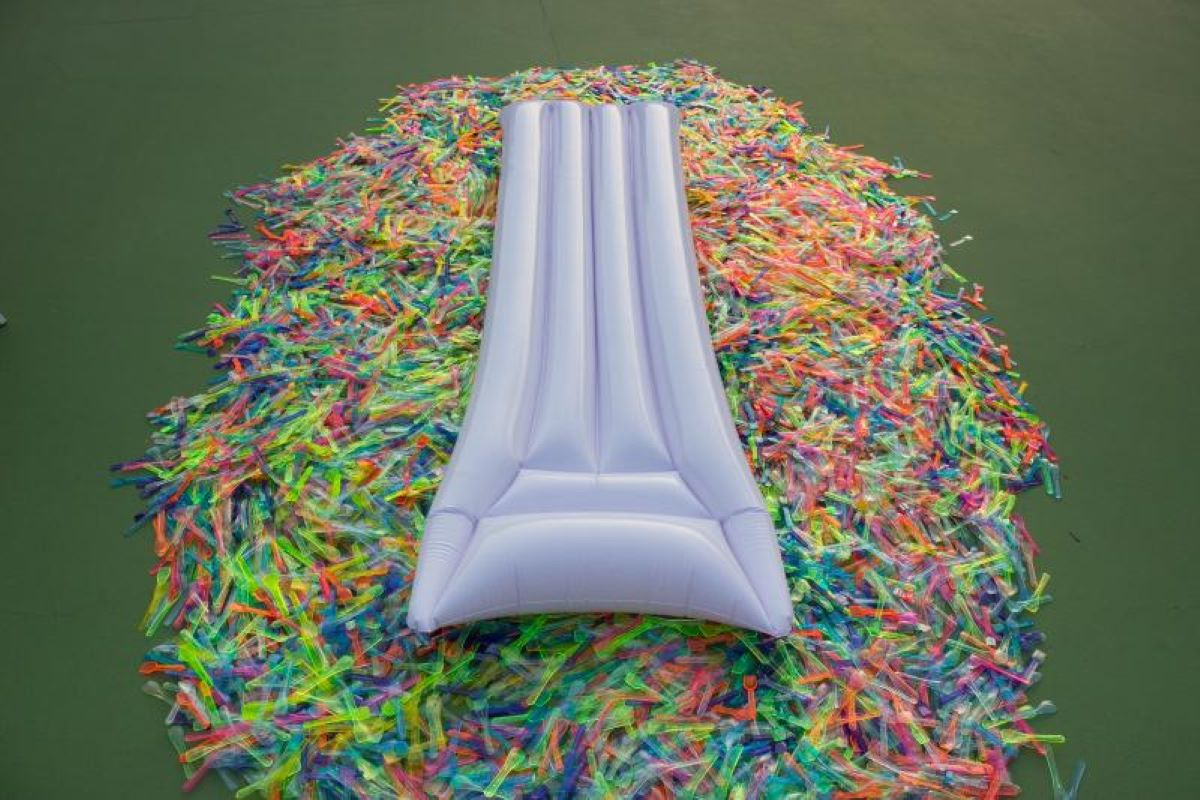 Foto id un lettino gonfiabile su un mare di cucchiaini di plastica da gelato colorati