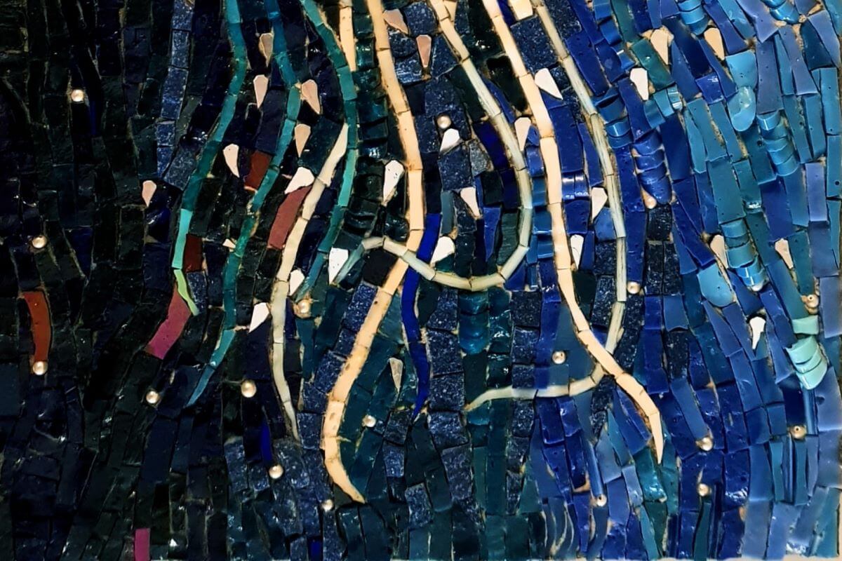 Foto di un dettaglio di mosaico blu con tessere d'oro come tentacoli di una medusa.