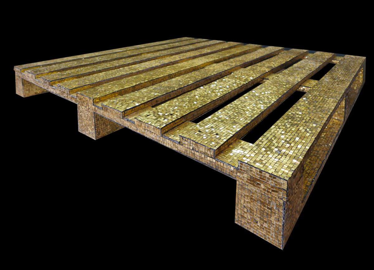 Foto di un pallet industriale coperto da tessere musive d'oro