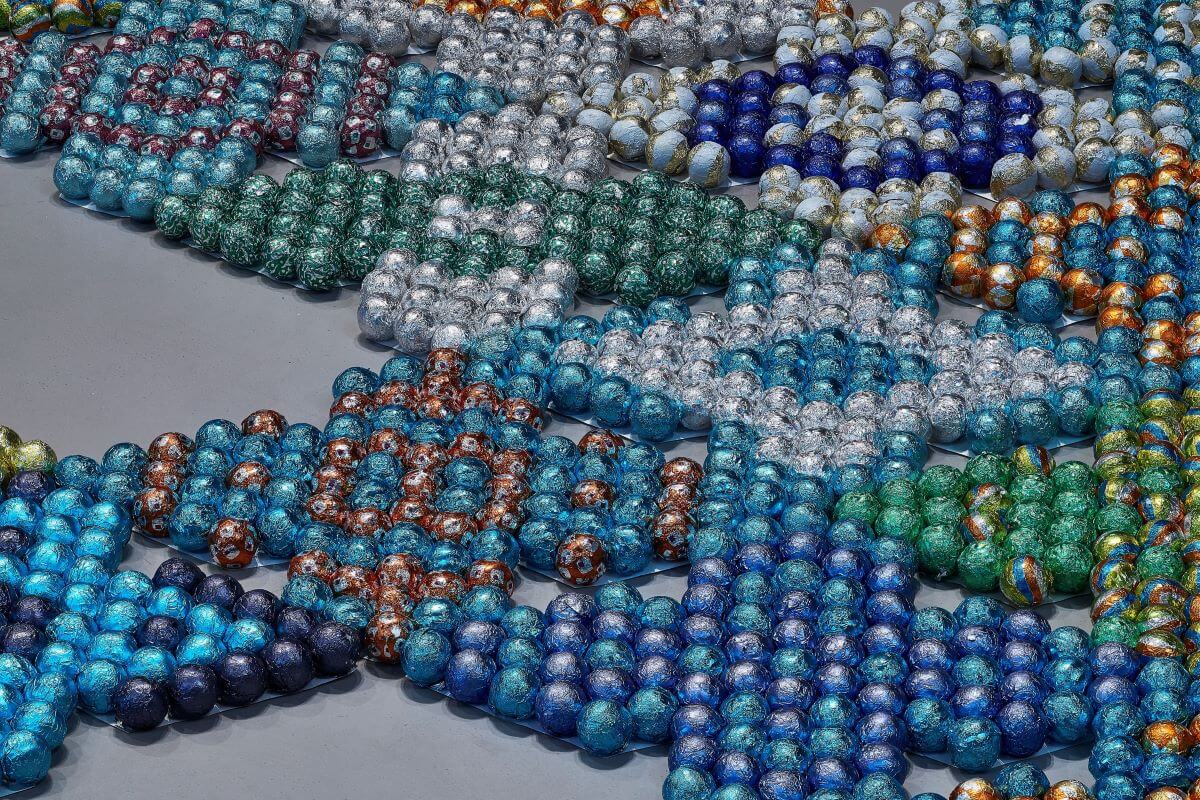 Foto di tante palline colorate che formano delle decorazioni geometriche.