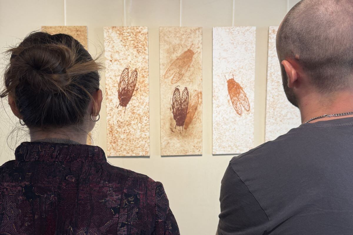 Foto di due persone di spalle che osservano opere a mosaico