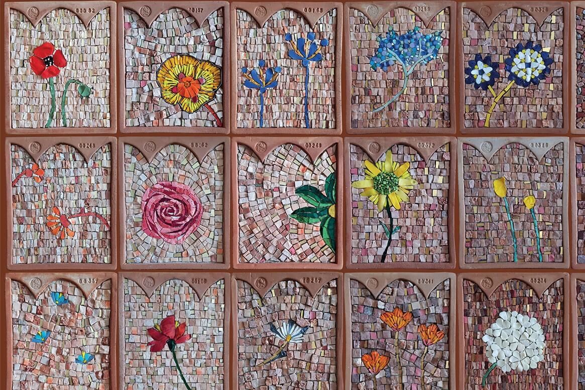 Foto di 15 cornici in terracotta con decorazione a mosaico e un fiore.