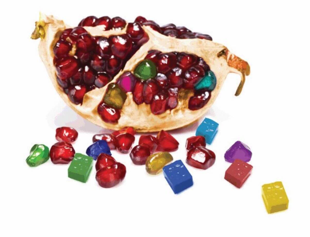 Foto di uno spicchio di melagrana con chicchi colorati come tessere di mosaico